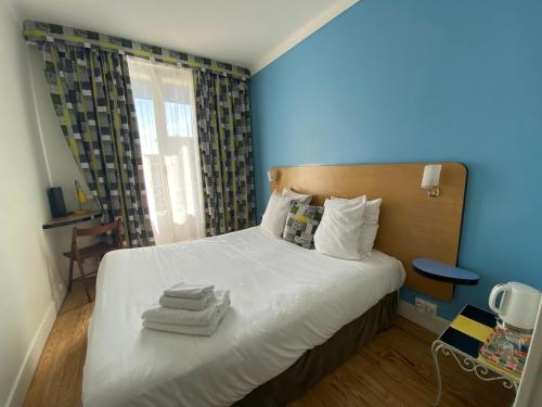 a bedroom with a bed with towels on it at Oscar Hôtel Le Havre Centre in Le Havre