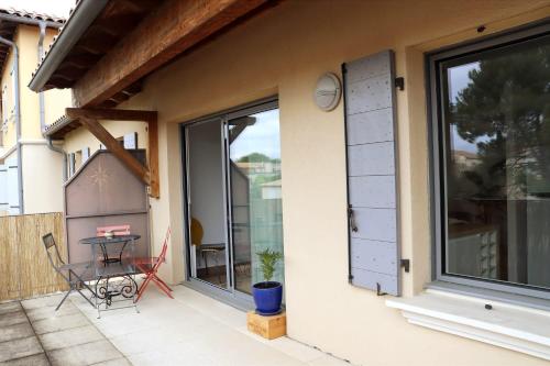 Elle comprend une petite terrasse avec une table et une fenêtre. dans l'établissement Uzès centre la TERRASSE des CAPUCINES avec Garage privée, à Uzès
