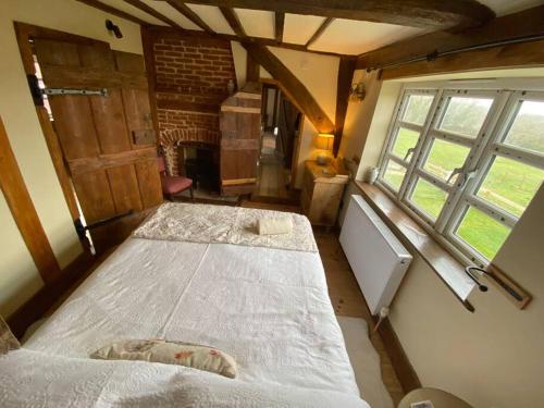 um quarto com 2 camas num quarto com janelas em A newly renovated, cosy escape in the beautiful Shepherd's Cottage em East Dereham