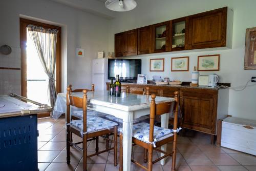 a kitchen with a table with chairs and a counter top at Casa Vacanze Feudi 1165 in Borgo Vodice