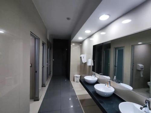 a bathroom with two sinks and two mirrors at CON GENERADOR Suite elegante piscina gym parqueo en el norte Gye in Guayaquil