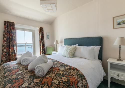 a bedroom with a large bed with towels on it at The Kellan in Mousehole