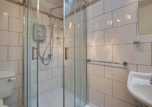 a bathroom with a glass shower and a sink at Kelynack in Porthleven