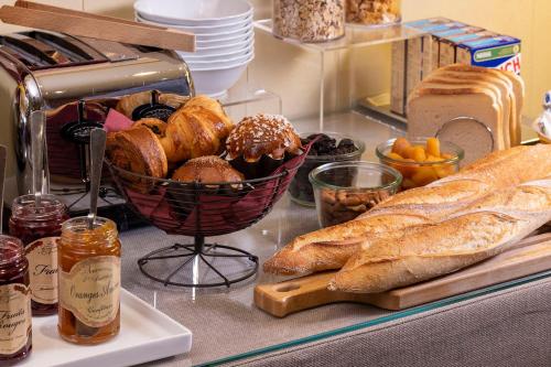 a table topped with bread and a basket of pastries at Hotel Clément in Paris