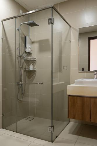 a glass shower in a bathroom with a sink at Cozy couple apartment suite in Masai