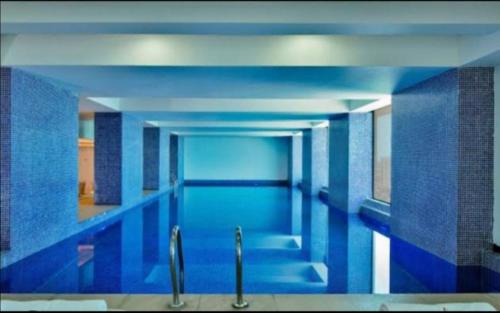uma grande piscina com paredes e tectos azuis em RB studio apartment with free Wi-Fi em Dar es Salaam