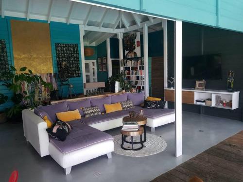 a living room with a purple couch and a table at Villa Cocon Bleu , plage à pied ! in Sainte-Luce