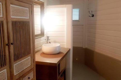 a bathroom with a white sink and a window at Villa Cocon Bleu , plage à pied ! in Sainte-Luce
