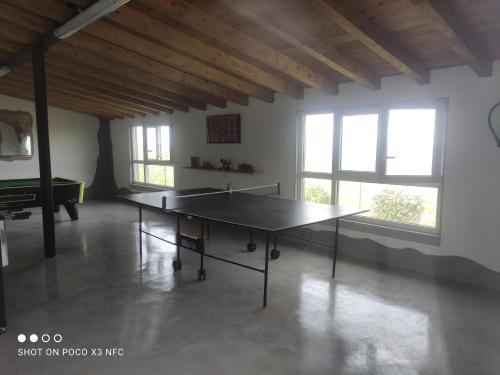 a ping pong table in a room with windows at Apartamentos Santa Justa in Ubiarco