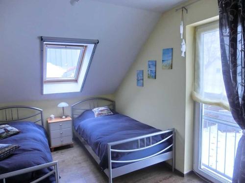 1 Schlafzimmer mit 2 Betten und einem Fenster in der Unterkunft Glowe Doppelferienhaus Sonnenstrand in Glowe