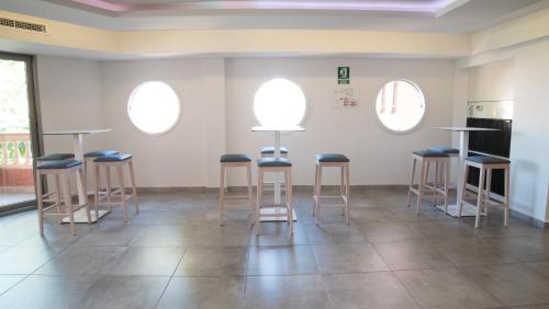 a room with four stools and three windows at Seramar Hotel Luna Park Adults Only in El Arenal