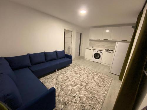a living room with a blue couch and a kitchen at CanBey Apartları in Adrasan