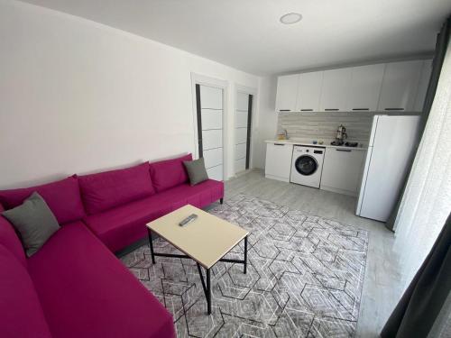 uma sala de estar com um sofá roxo e uma mesa em CanBey Apartları em Adrasan