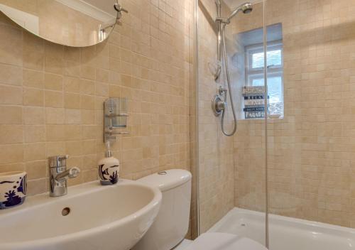 a bathroom with a toilet and a sink and a shower at 4 Apartment Pixies Holt in Looe