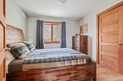 a bedroom with a bed and a wooden door at 34- Chalet à louer à Stoneham in Stoneham