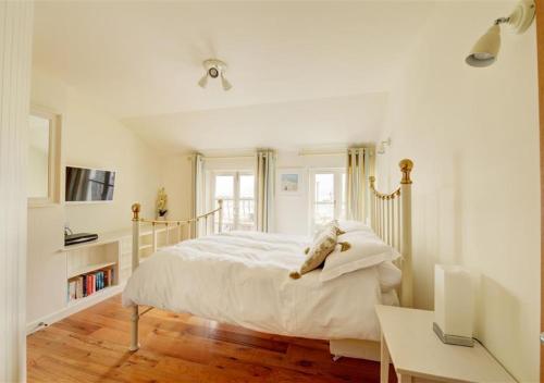 Habitación blanca con cama y escritorio en 4 Seaview en Looe