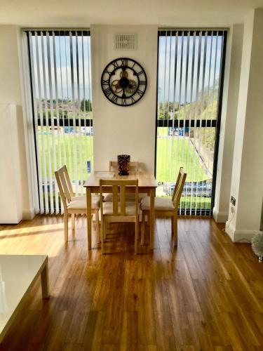 a dining room with a table and chairs and a clock at Castle Quarter - Free Parking - Fast Fibre in Bedford