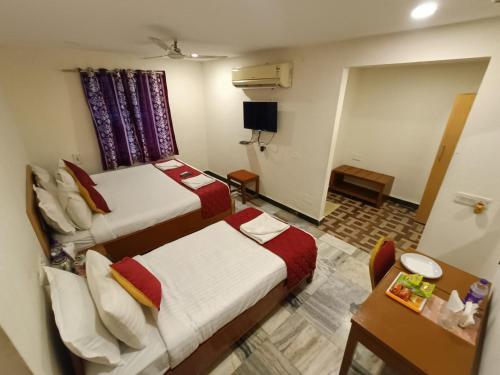 a hotel room with two beds and a table at GT Grande Hotel-Near US Consulate in Chennai