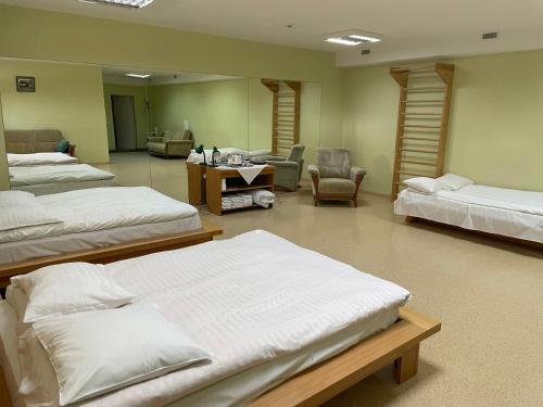a room with three beds and a living room at Aismares Hostel in Klaipėda
