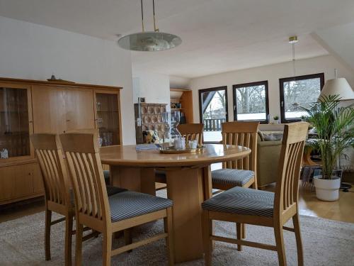 uma cozinha com uma mesa de madeira e cadeiras em Ferienwohnung im Hambach em Bad Berleburg