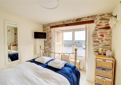 a bedroom with a bed and a view of the ocean at 5 Seaview in Looe
