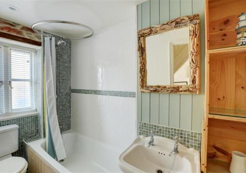 a bathroom with a sink and a mirror and a toilet at 5 Seaview in Looe