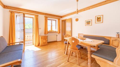 a living room with a wooden table and chairs at Demelhof in Reit im Winkl