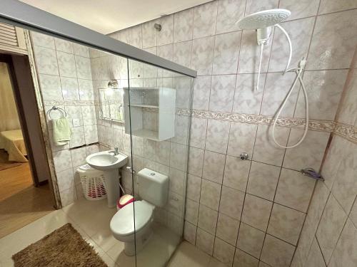 a bathroom with a shower and a toilet and a sink at Pousada Residencial - PVH in Porto Velho