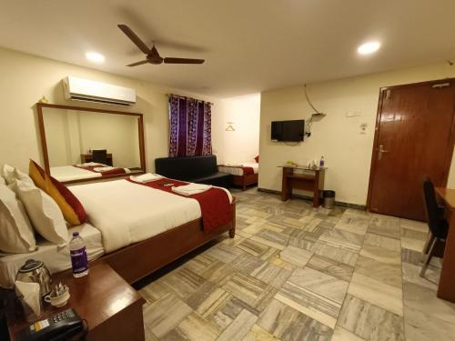 a hotel room with a large bed and a table at GT Grande Hotel-Near US Consulate in Chennai