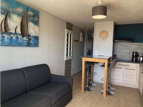 un salon avec un canapé et une cuisine dans l'établissement Appartement près de la plage avec balcon et parking privé - FR-1-336-69, à Longeville-sur-Mer