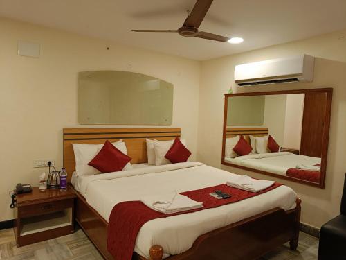 a hotel room with two beds and a mirror at GT Grande Hotel-Near US Consulate in Chennai