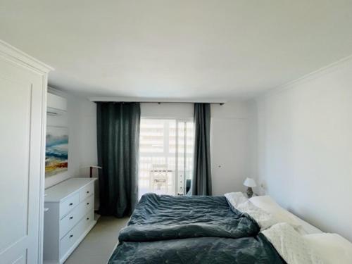 um quarto com uma cama e uma janela em Duplex Penthouse em Calpe
