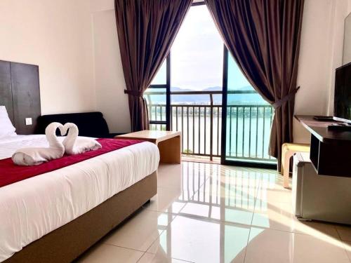 a hotel room with a bed with two swans on it at Marina Heights Hotel Residences in Lumut