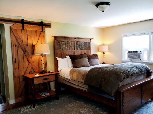 1 dormitorio con 1 cama con cabecero de madera y ventana en Farm Road Estate, en West Dover