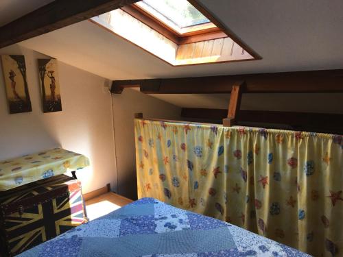 une chambre avec un lit et une lucarne dans l'établissement Pavillon avec piscine commune et jardin à 800m de la plage - FR-1-336-72, à Saint-Vincent-sur-Jard