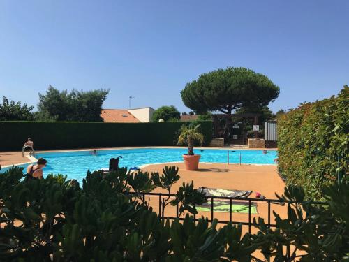- une grande piscine avec des personnes dans l'établissement Pavillon avec piscine commune et jardin à 800m de la plage - FR-1-336-72, à Saint-Vincent-sur-Jard