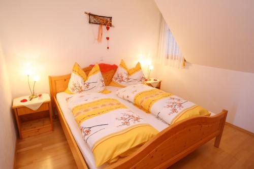 a bedroom with a bed with yellow and white sheets at Apfelhof FLIEDER in Kukmirn