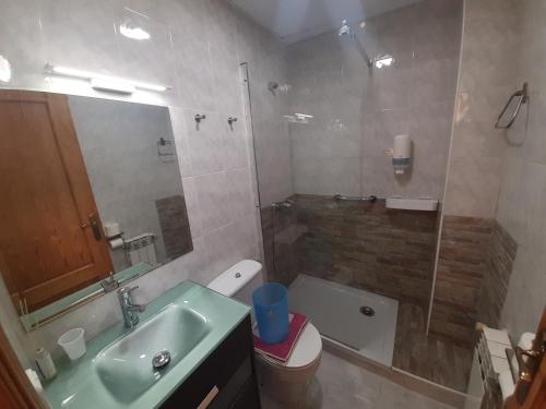 y baño con lavabo, aseo y ducha. en Hostal Escarla, en Aren