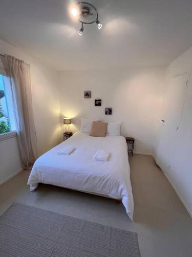 a bedroom with a white bed and a window at Grand appartement a 300M de la plage in Sainte-Maxime