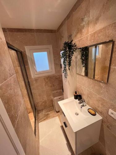 a small bathroom with a sink and a mirror at Grand appartement a 300M de la plage in Sainte-Maxime