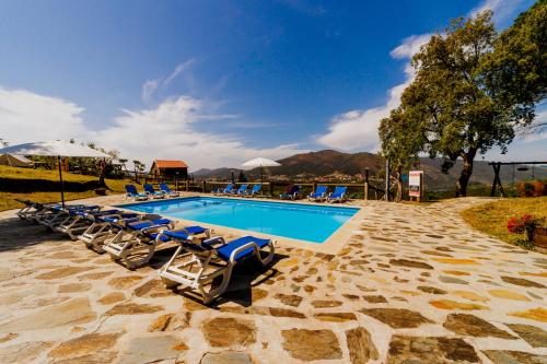 a swimming pool with lounge chairs and a resort at Arrabia Guest Houses Glamping in Raiva