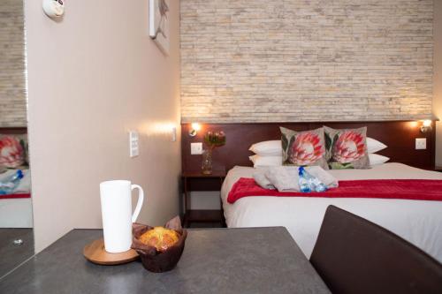 ein Hotelzimmer mit einem Bett und einem Tisch mit einem Laptop in der Unterkunft Alucarni Guest House with solar energy in Upington