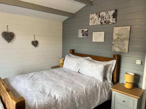 a bedroom with a bed and two hearts on the wall at Blackbrook Lodge Cabin in Turnditch