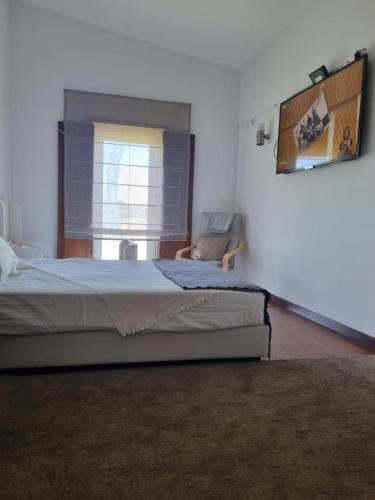 a bedroom with a bed and a chair and a window at Villa Infinity in Cuba