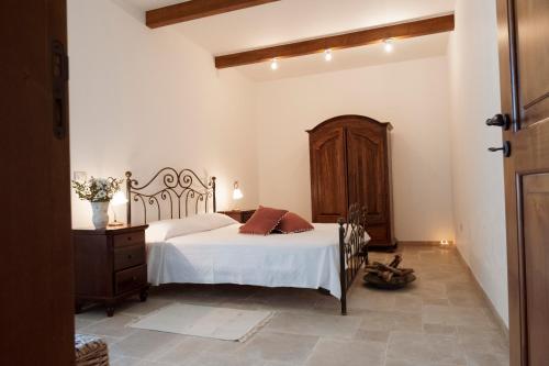 a bedroom with a white bed and a wooden cabinet at I trulli di Kate in Monopoli