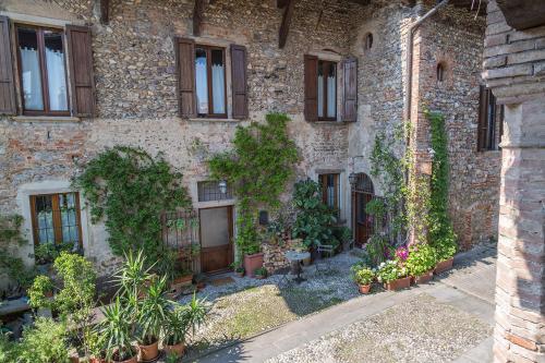 an old stone building with plants and windows at La Locanda della Torre "Foresteria Lombarda" in Marne di Filago