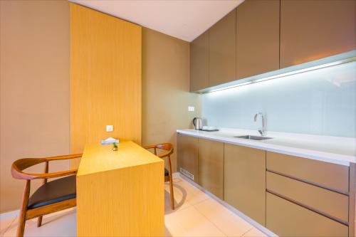 Greystone 99 Suites في ميلاكا: مطبخ صغير مع حوض وطاولة