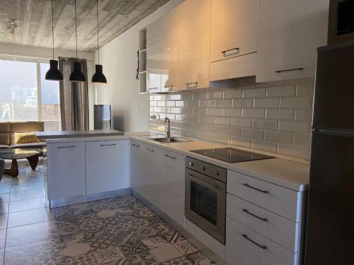 a kitchen with white cabinets and a sink and a stove at Sliema Distant Seaview Penthouse in Sliema