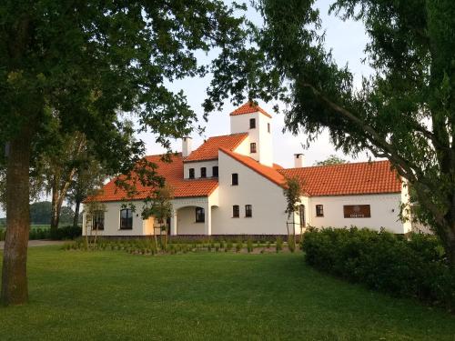 une grande maison blanche avec un toit orange dans l'établissement Landhuys Odette, à Retie