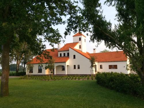 a large white house with an orange roof at Landhuys Odette in Retie